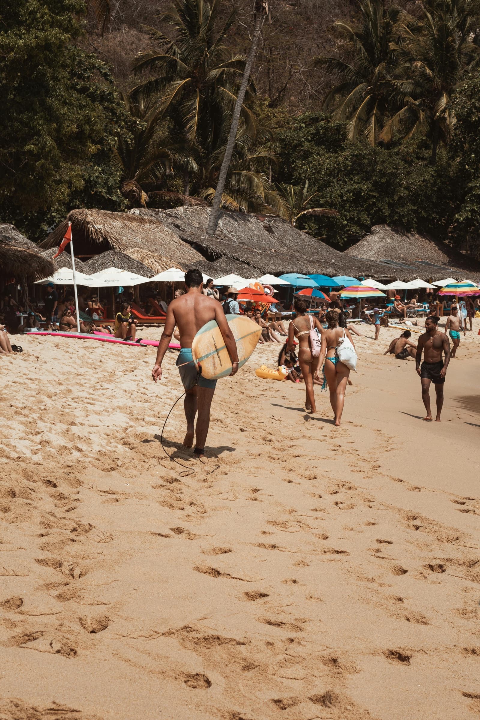 Surfers and beachgoers on the sand at Puerto Escondido on Mexico's Pacific coast